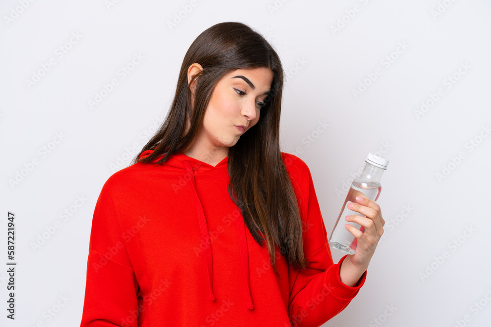 Young Brazilian woman with a bottle of water isolated on white background with sad expression Young Brazilian woman with a bottle of water isolated on white background with sad expression