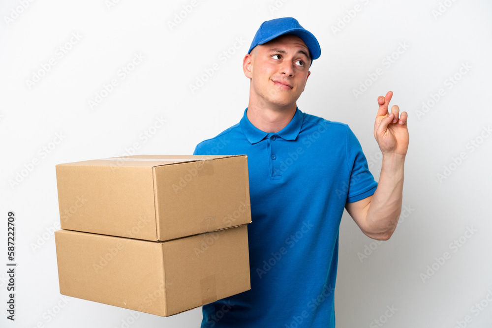 Young delivery Brazilian man isolated ops white background with fingers crossing and wishing the best Young delivery Brazilian man isolated ops white background with fingers crossing and wishing the best