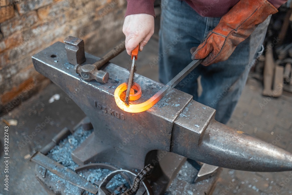 a man uses tools to make blacksmithing steel on an anvil