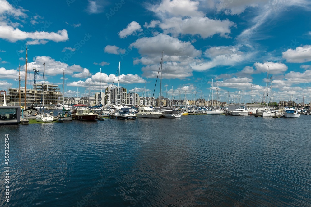 Boats are docked in the water with buildings in the background