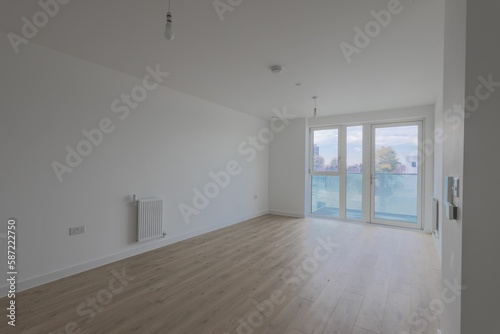 Wooden floor in an empty white room and a balcony