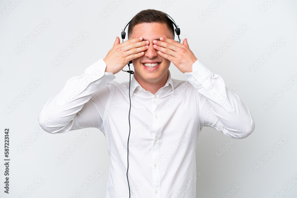 Telemarketer Brazilian man working with a headset isolated on white background covering eyes by hands Telemarketer Brazilian man working with a headset isolated on white background covering eyes by hands