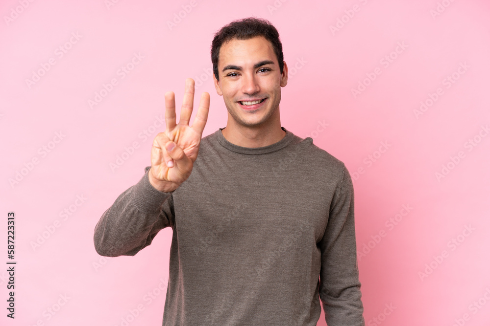 Young caucasian man isolated on pink background happy and counting three with fingers Young caucasian man isolated on pink background happy and counting three with fingers