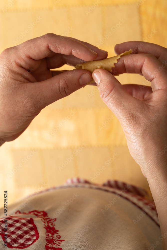 Fototapeta premium Explore the artistry up close as skilled hands intricately shape chebakia dough, transforming it into edible masterpieces.
