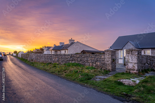 Sunrise at the end of the road with old irish cottages and stone walls on Inishmore island © Eli Bolyarska