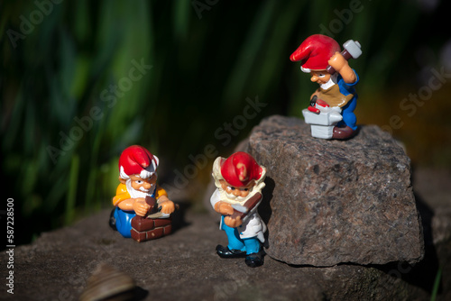 Musical trio of gnomes.Working gnomes in a fairy garden.Floral landscape with a fairy-tale character.