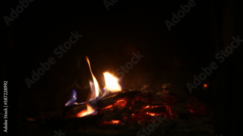 Close up the lash of flames, fire, hot coals on a dark background