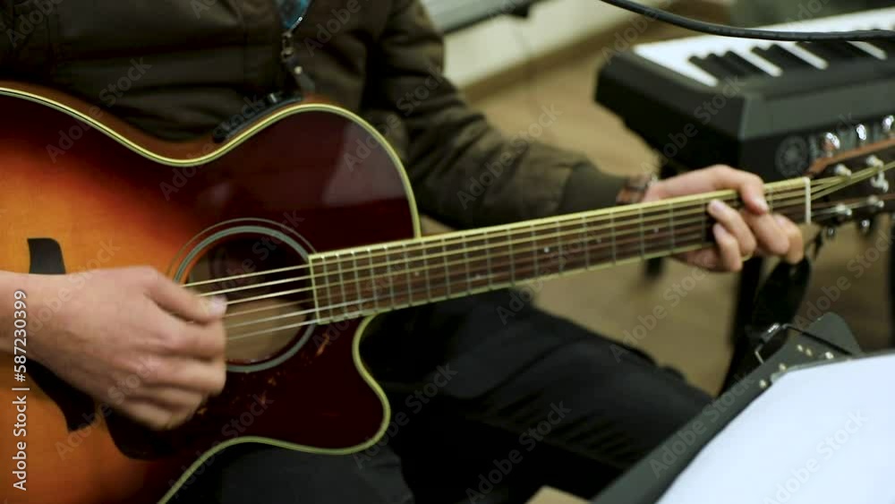 A man playing the guitar in the studio - close up A man playing the guitar in the studio - close up
