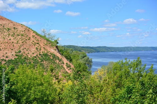 A view to the lake with clay mountain on foreground and blue sky with clouds 