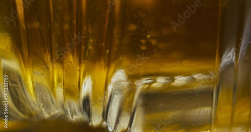 Macro close up of ice dropping into sctoch in fancy glass and bring stirred with barspoon photo