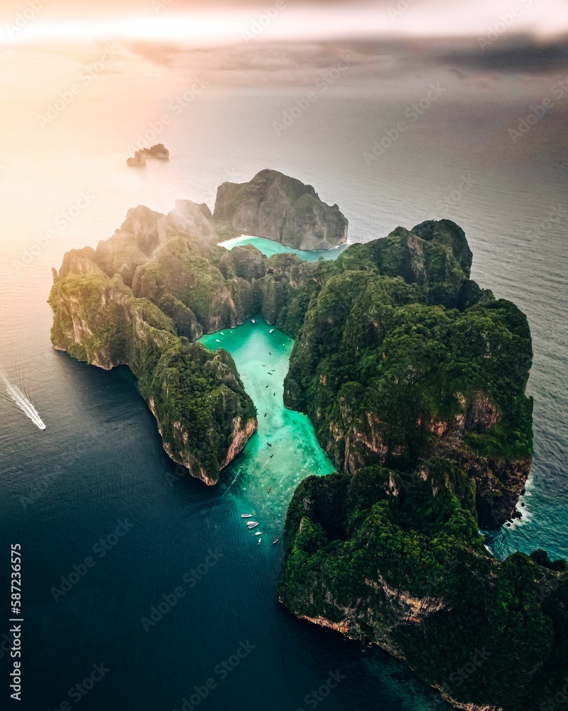 Obraz premium Aerial view of a forested green rocky island with a sandy beach in Thailand, Krabi, Phi Phi Island