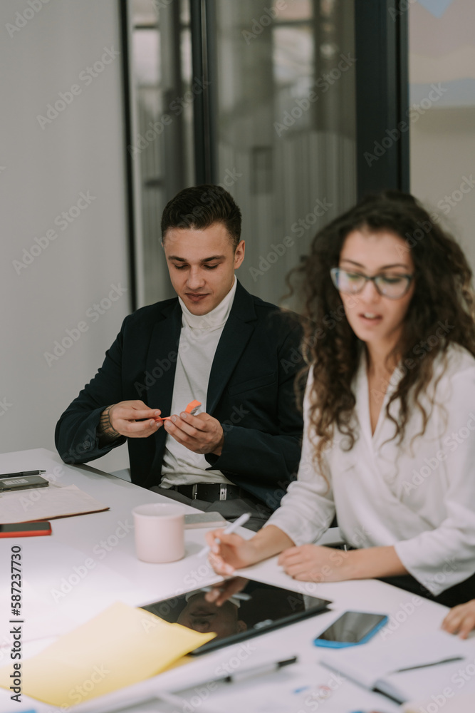 Good looking male person taking a sticky note for his female colleague Good looking male person taking a sticky note for his female colleague