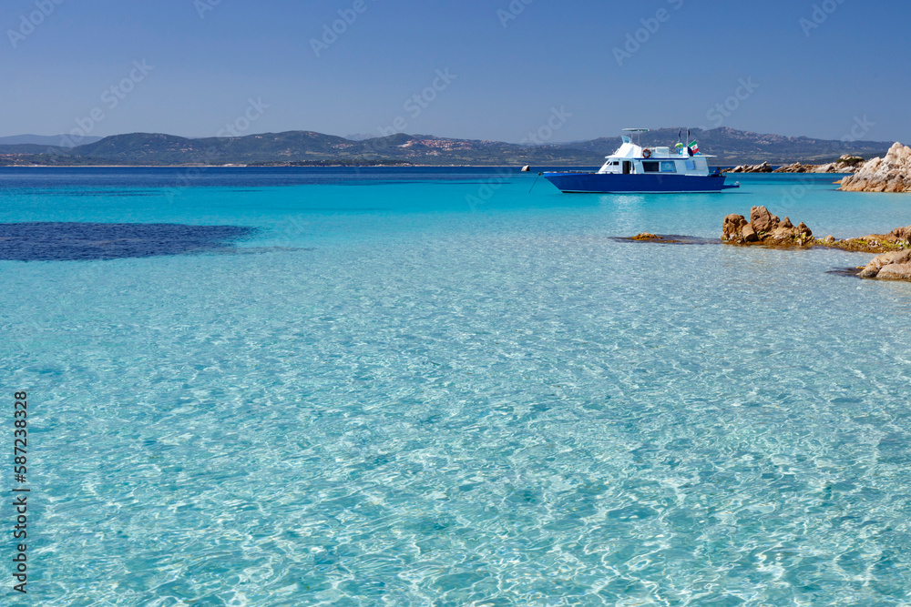 foto panoramica di una costa con il mare cristallino con un imbarcazione sullo sfondo 