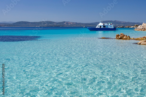 foto panoramica di una costa con il mare cristallino con un imbarcazione sullo sfondo  photo