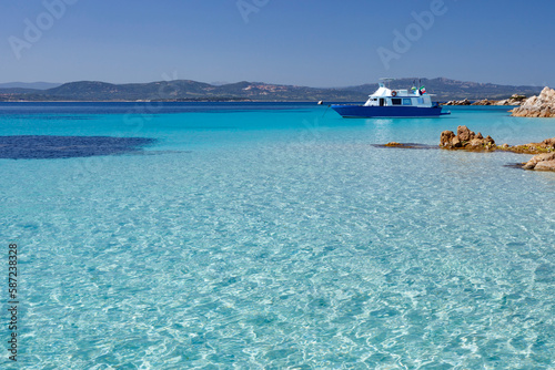 foto panoramica di una costa con il mare cristallino con un imbarcazione sullo sfondo 