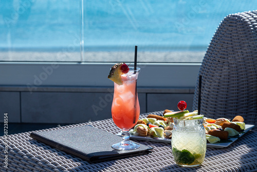 cocktail con aperitivi serviti di fronte a una spiaggia che si vede sullo sfondo  photo