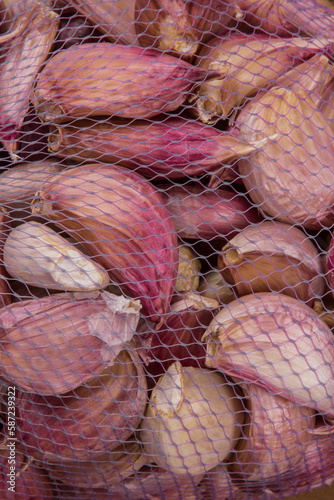 Allho roxo em pedaços separados dentro de um saco artesanal vazado