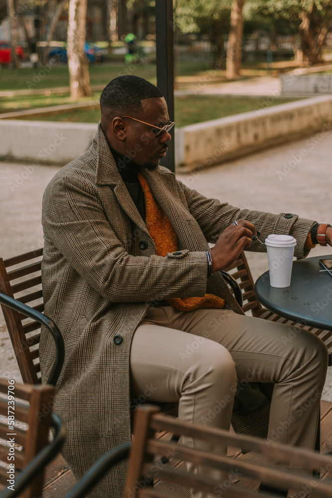 Stylish black male person is about to take a sip of his tea