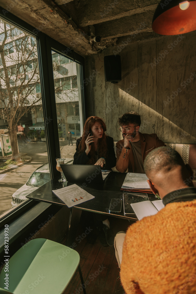 Young male business person is trying to figure it out where his female partner did a mistake at her daily task. She is worried and looking at him. Black male person writing new ideas in a notebook