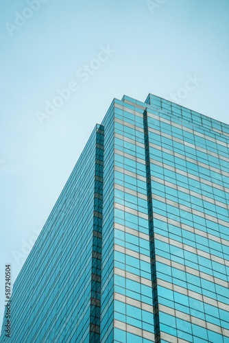 Low-angle shot of a tall glass office building with lots of windows, in Bangkok