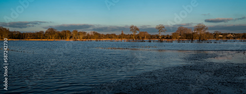Reflets de nuages ​​roses dans un ciel bleu sur l'eau au dessus des marais en fin de journée. Inondation des champs après la pluie. Couleur d'hiver en Charente maritime à Saint Georges de Didonne.
 photo