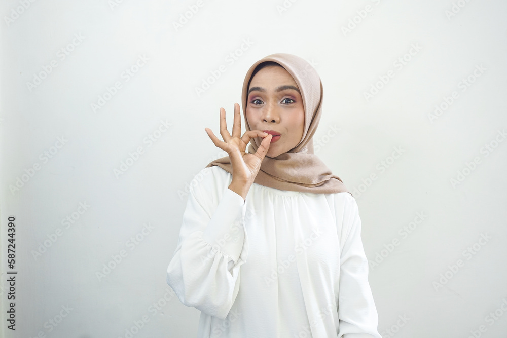 Beautiful smiling Asian Muslim woman wearing hijab Using mobile phone, typing sms message isolated on white background studio portrait. People religious lifestyle concept