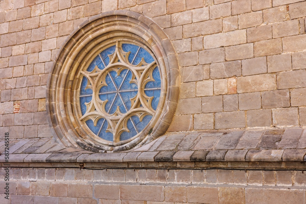 Rose window, gothic architecture with a shield over the stained glass.