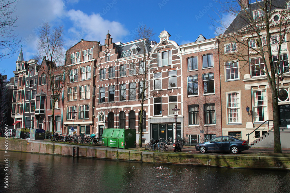 Naklejka premium old brick houses and canal in amsterdam (the netherlands) 