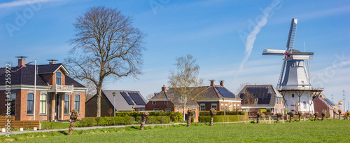 Panorama of old houses and historic windmill in Klein Wetsinge, Netherlands photo