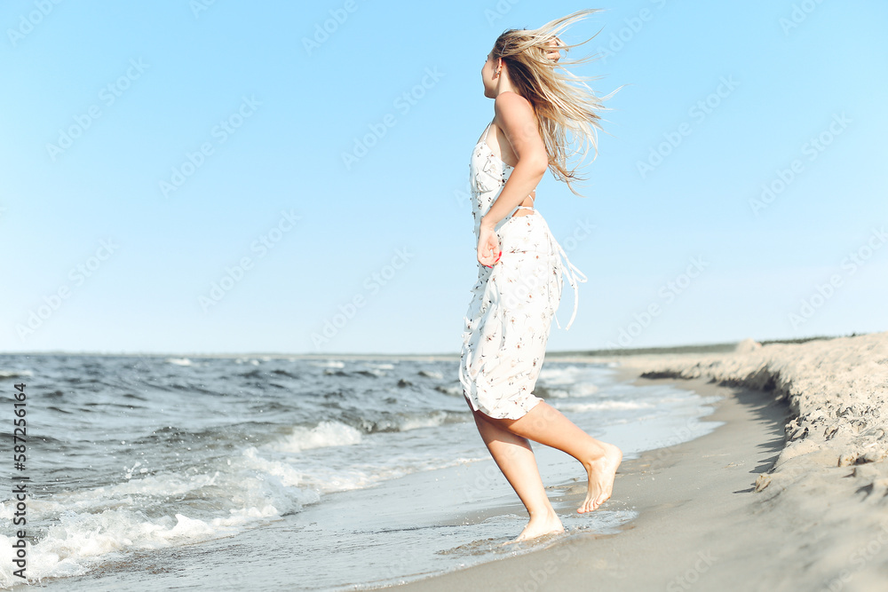 Happy blonde beautiful woman having fun on ocean beach while dancing in waves Happy blonde beautiful woman having fun on ocean beach while dancing in waves