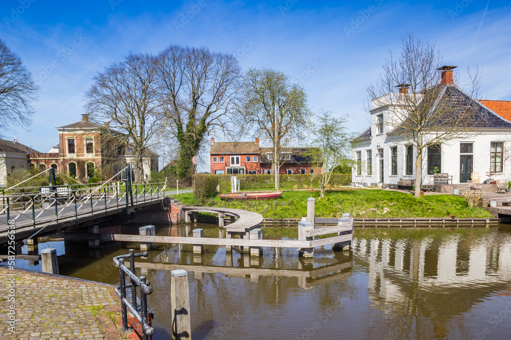 Bridge crossing the Winsumerdiep river in historic village Onderdendam, Netherlands Bridge crossing the Winsumerdiep river in historic village Onderdendam, Netherlands