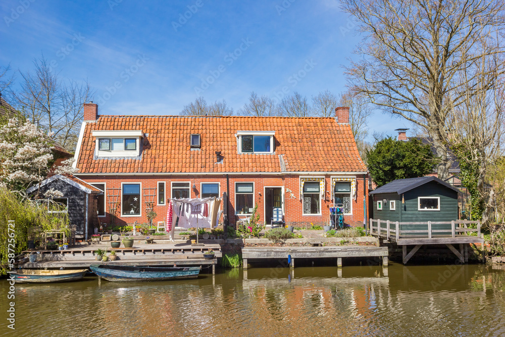 Boats at the jetty of little house in Onderdendam, Netherlands