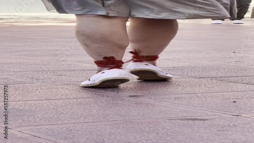 vertical video feet of a woman dancing sardanas, with special shoes and typical clothing for dancing sardanas, typical dance in Catalonia