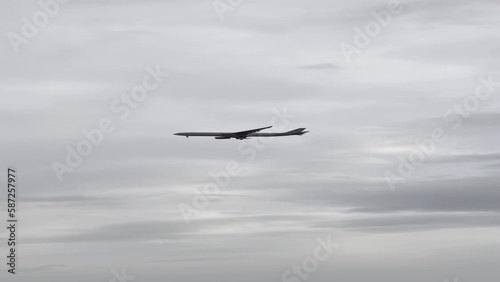 vertical video of a plane flying through the sky, near the airport, preparing to land