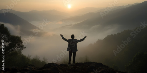 Businessman shouting with raised hands on top of mountain