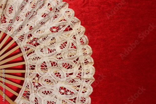 Vintage Lace Hand Fan On Red Velvet Background photo