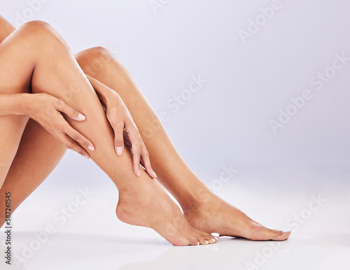 Closeup, skincare and legs with cosmetics, dermatology and treatment against a white studio background. Feet, woman and female with wellness, salon grooming and luxury with care, beauty and health © Malik/peopleimages.com
