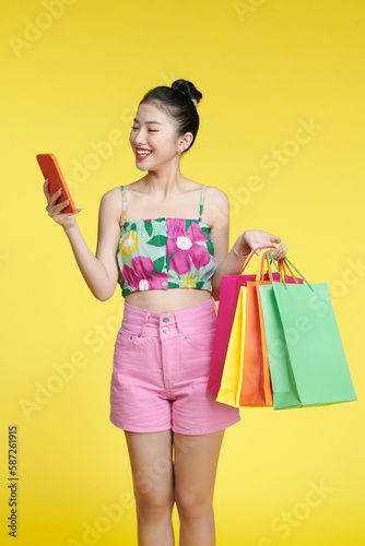 asian woman are holding shopping bags and smartphone with face happily