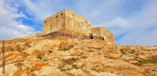 The stone castle of Volterraio stands on a mountain against the blue sky. Panorama. photo