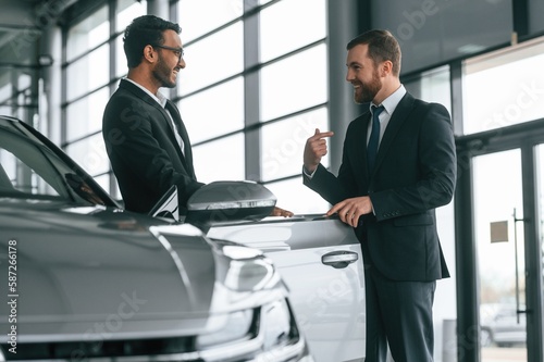 Two businessmen are working together in the car showroom © standret