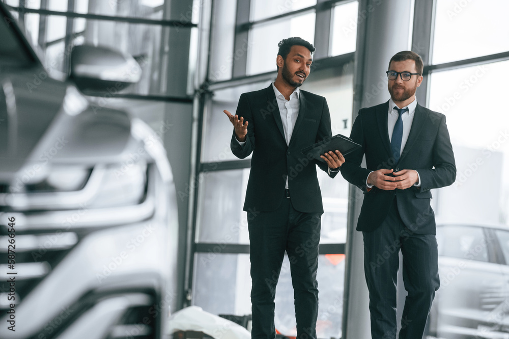 Fototapeta premium Talking about automobile. Man is consulting the customer in the car showroom