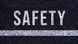 Safety first text written on the road in middle of the asphalt road, Safety first word on street.