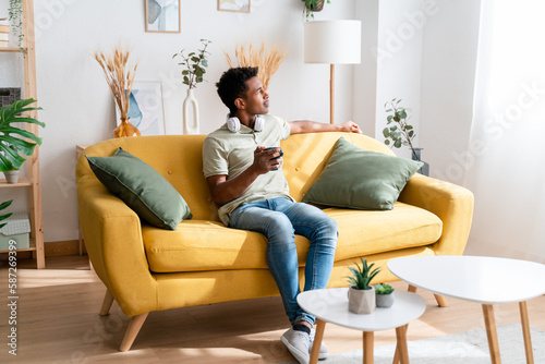 Cheerful black man relaxing at home