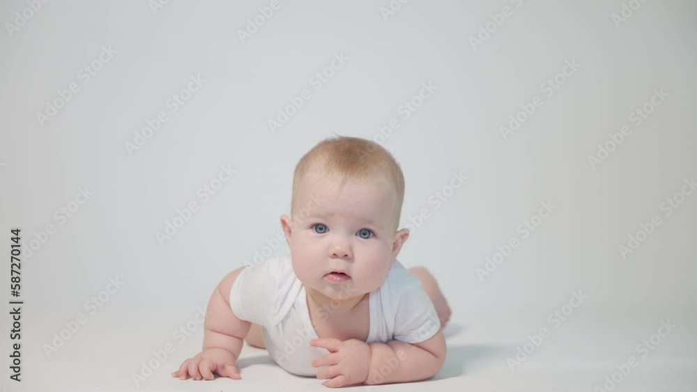 infant on white background first attempts to crawl on his knees infant on white background first attempts to crawl on his knees