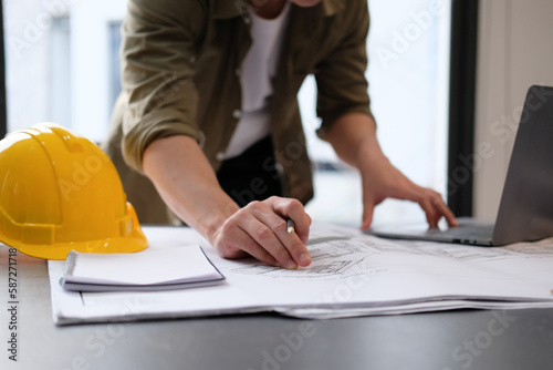 architect man working with laptop and blueprints,engineer inspection in workplace for architectural plan,sketching a construction project ,selective focus,Business concept vintage color