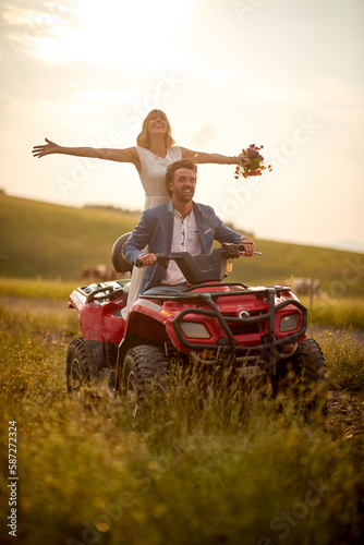 Young newlyweds are enjoying the scenery while riding the quad in the nature. Riding, nature, wedding, activity