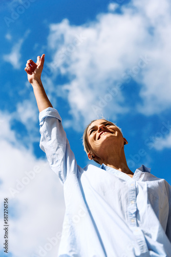 Businesswoman pointing to the sky while smiling