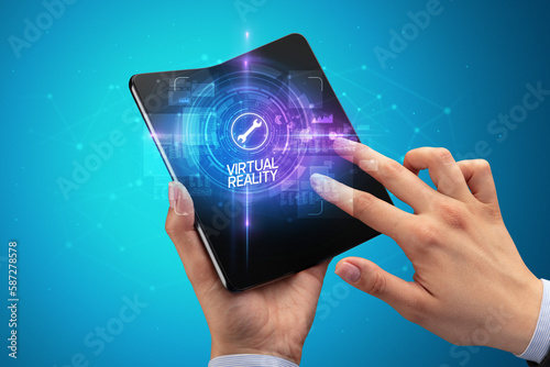 Billede på lærred Businessman holding a foldable smartphone, technology concept
