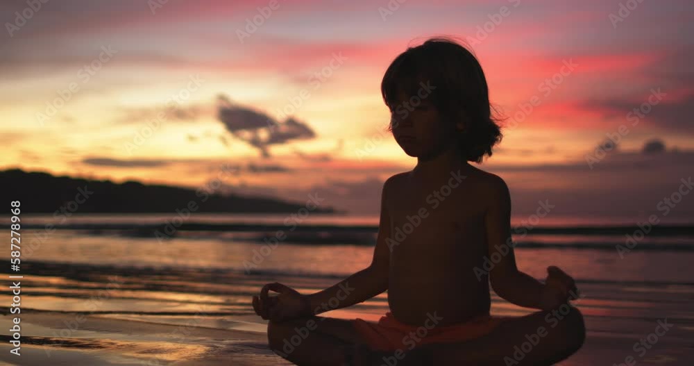 Silhouette little dreamer sitting in lotus position and meditating Silhouette little dreamer sitting in lotus position and meditating