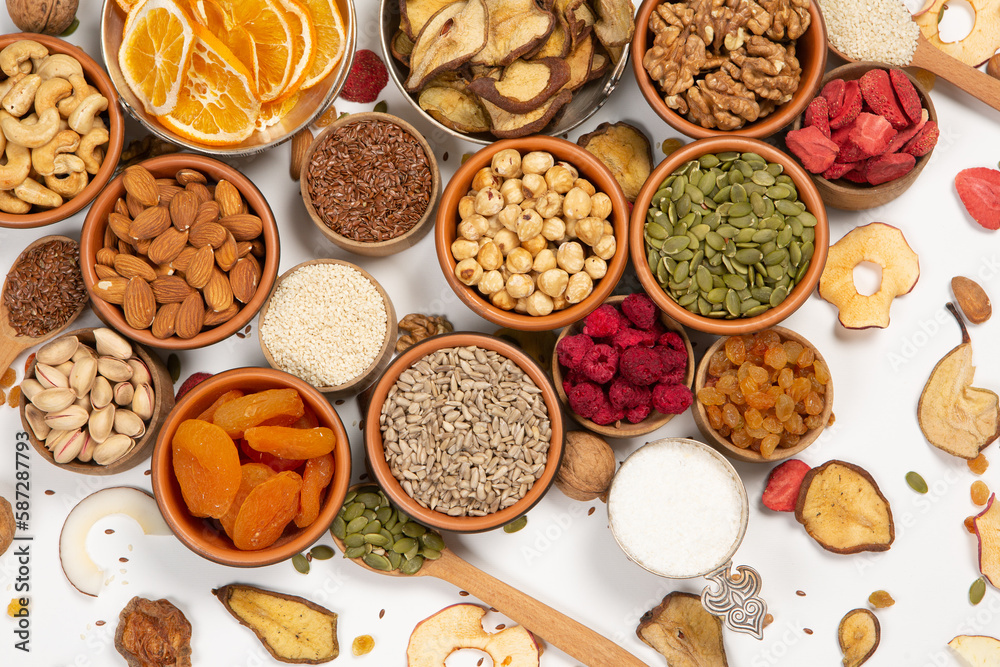 Healthy vegetarian food concept. Assortment of dried fruits, nuts and seeds on white background. Top view. Mixed nuts set closeup. Healthy vegetarian food concept. Assortment of dried fruits, nuts and seeds on white background. Top view. Mixed nuts set closeup.